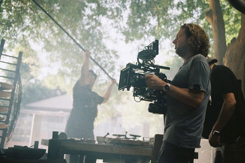 Kameramann Maher Maleh an einem Filmset, eine Filmkamera in den Händen haltend